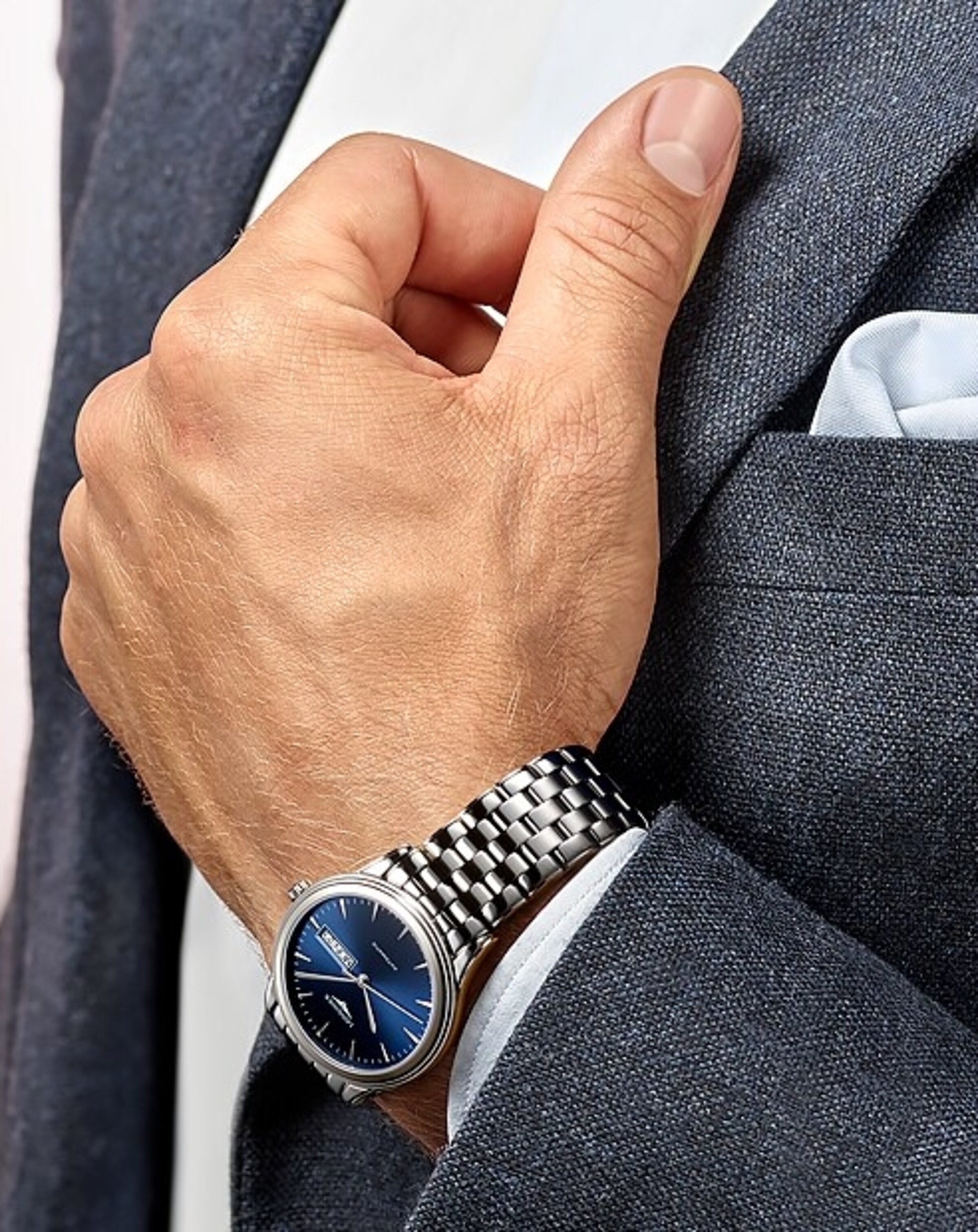 a Longines watch on the wrist of a man in suit
