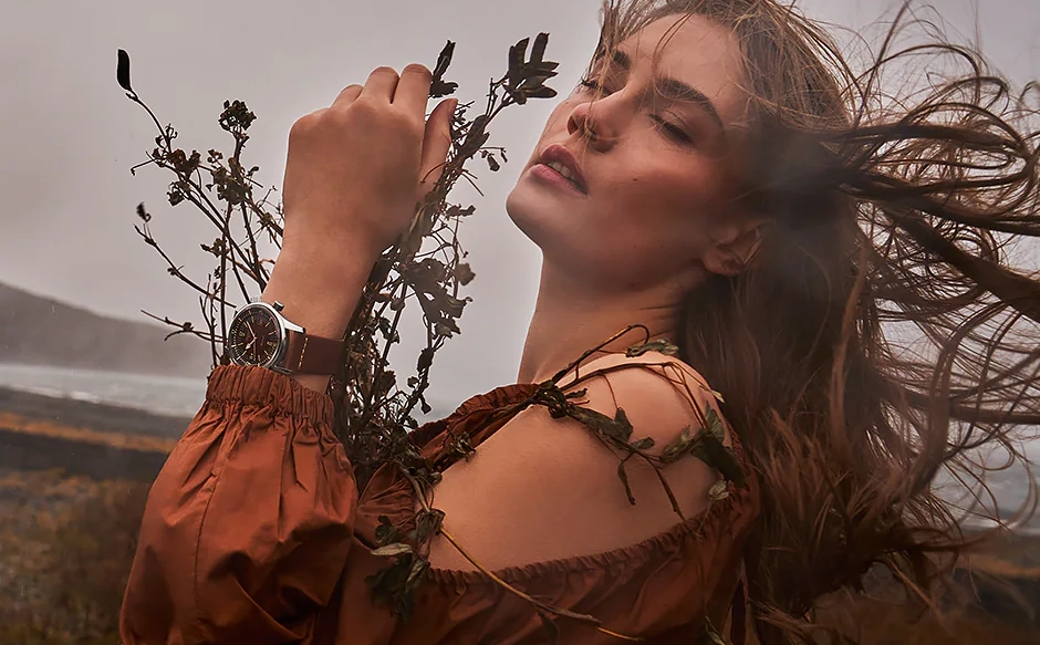 a woman in nature is wearing a Longines watch