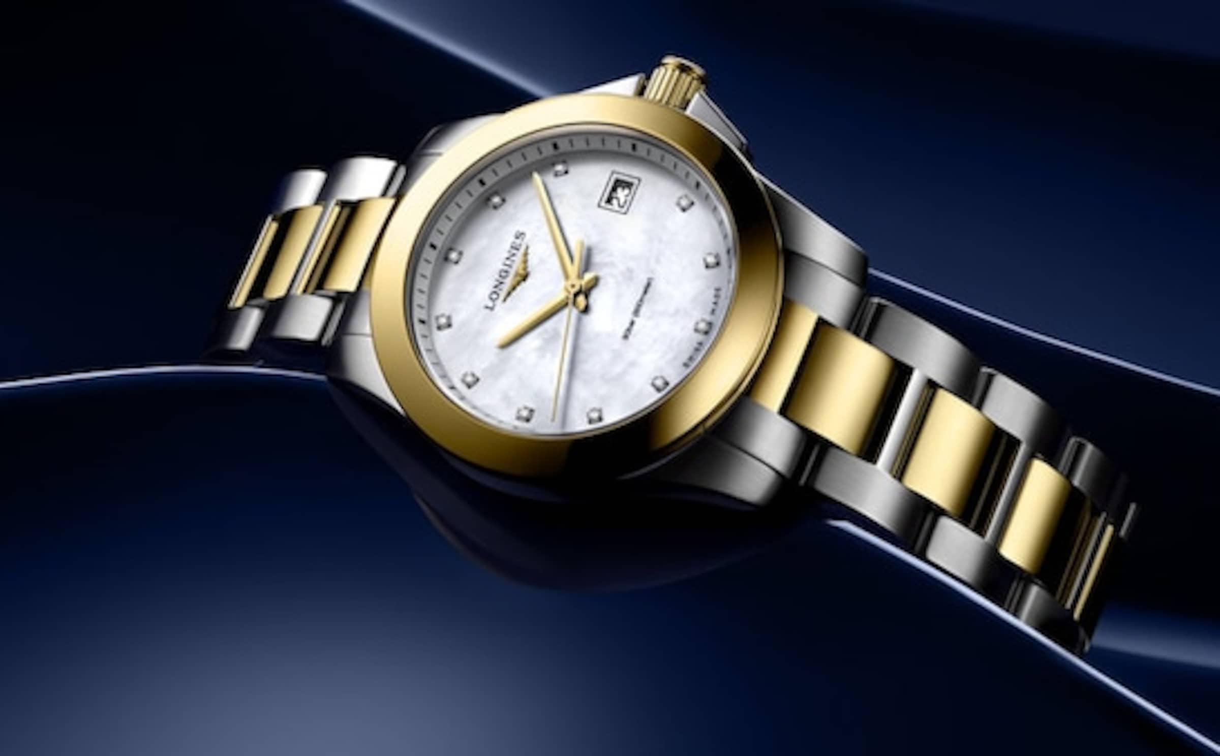 Longines Conquest gold watch on blue background