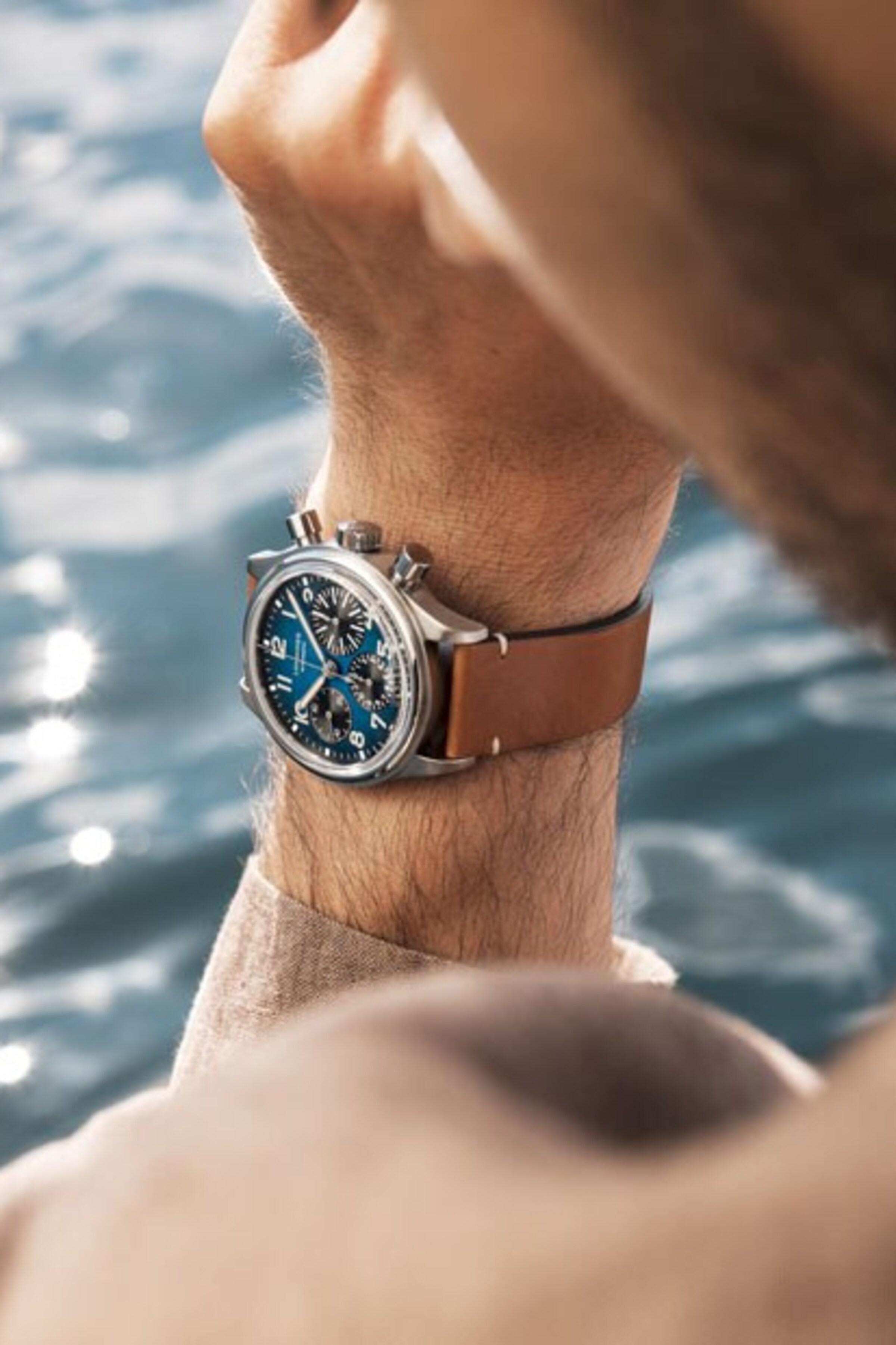 a Longines blue watch with brown strap