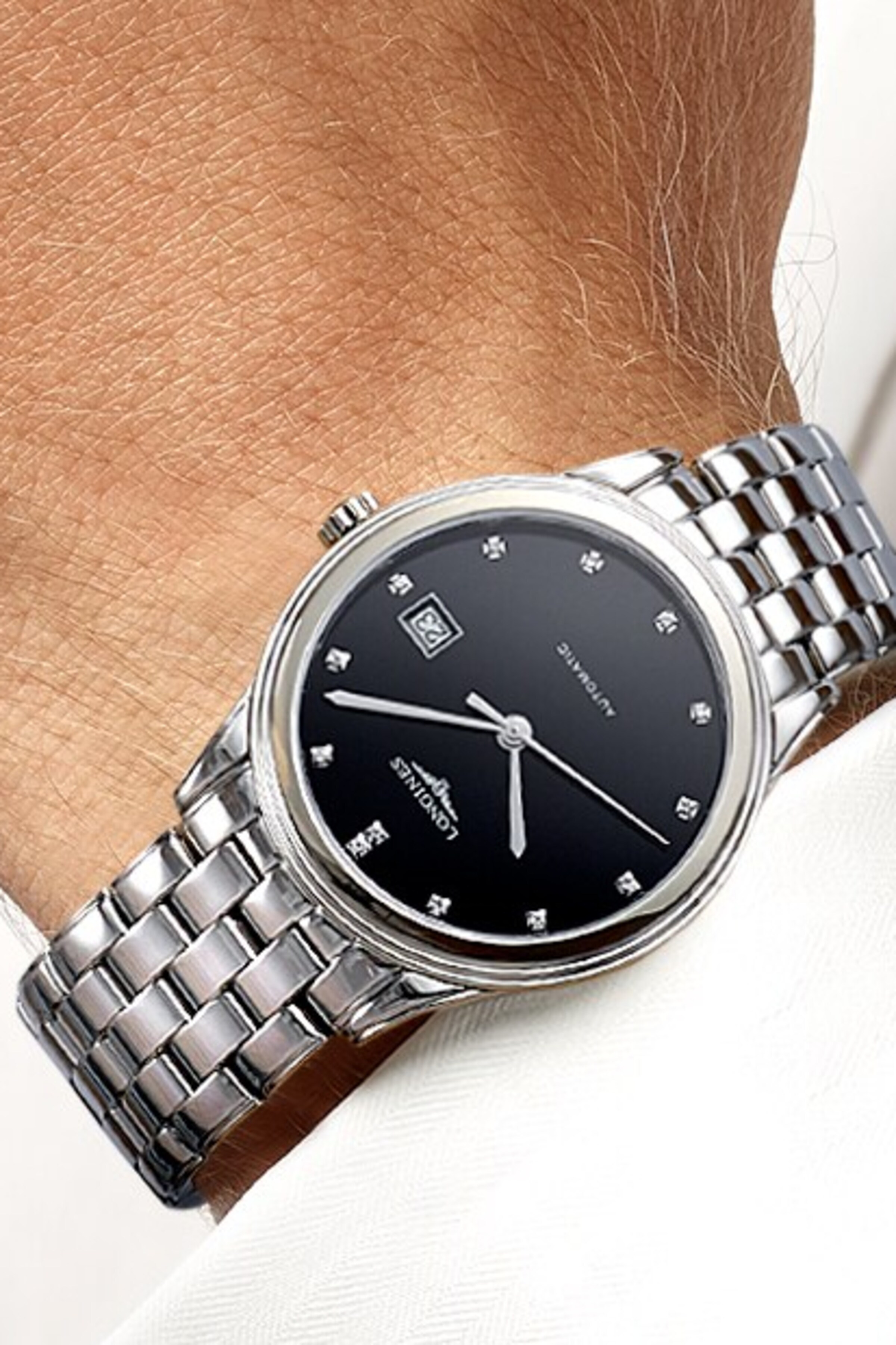 a Longines watch with diamonds on a male wrist