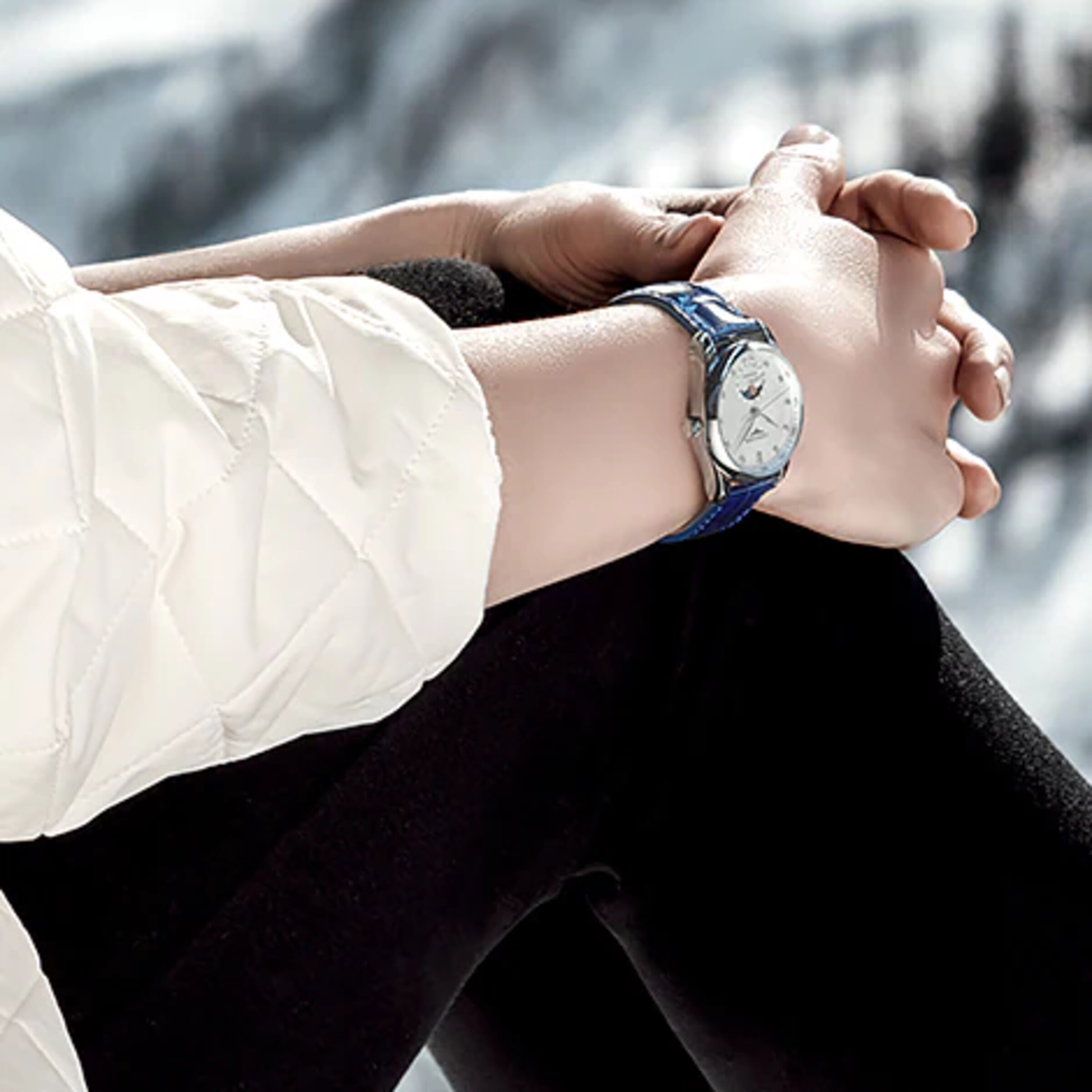 A woman is wearing a blue The Longines Master Collection watch