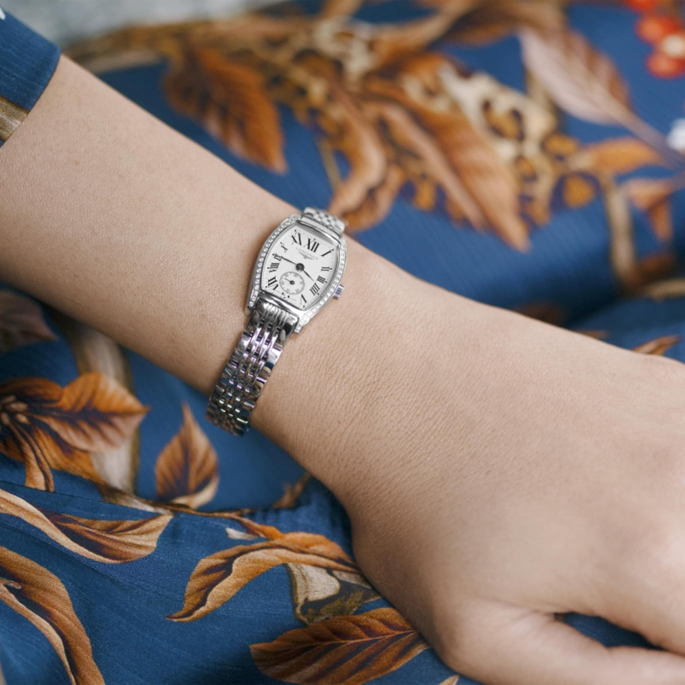 A woman is wearing a Longines evidenza watch